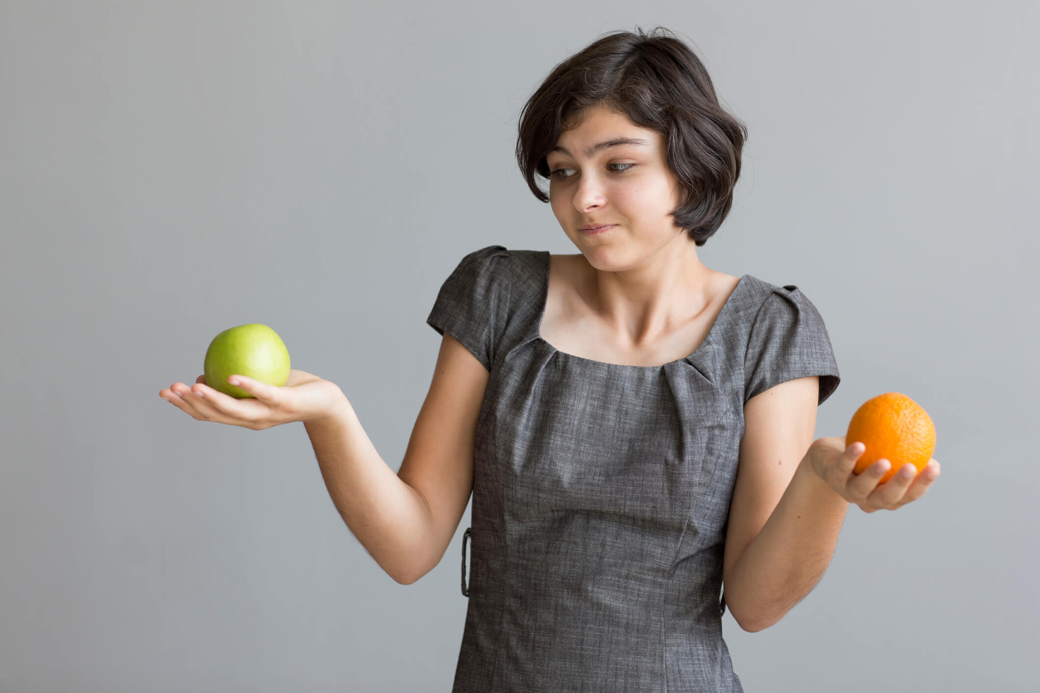 woman comparing apples to oranges wondering why her credit score isn't the same everywhere